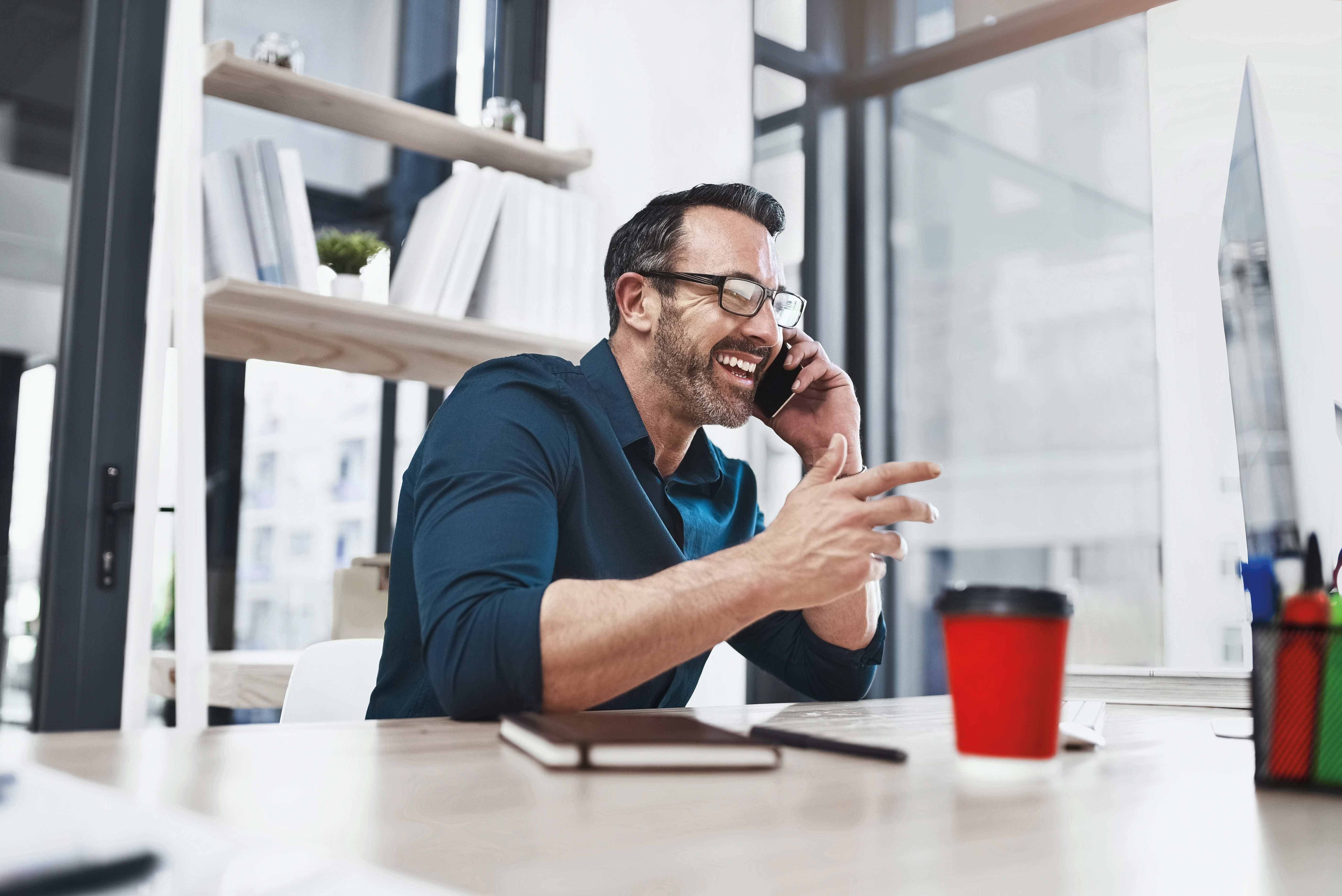 Man wearing blue shirt talking on the phone